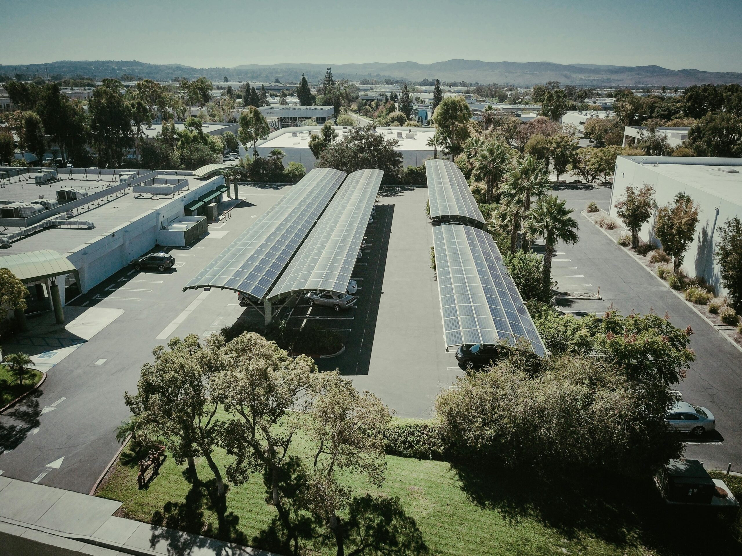 Aerial shot of solar panel installations in a suburban neighborhood under clear skies.